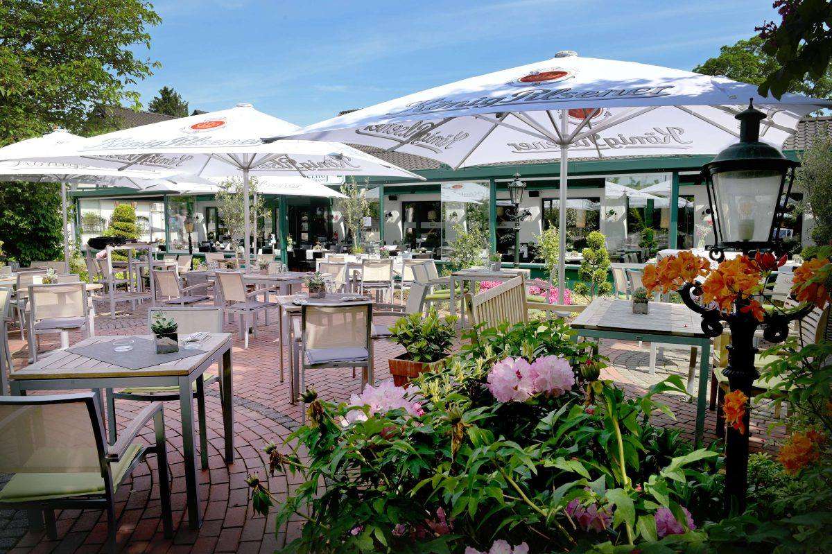 Biergarten mit Sonnenschirmen und blühenden Pflanzen